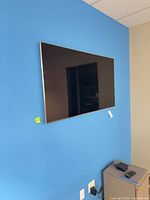 Wall-mounted Samsung 55" TV on blue wall