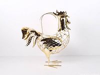 Full view of gold-tone metal rooster egg basket standing on tripod feet with loop handle