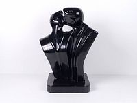 Front view of black ceramic kissing couple sculpture on rectangular base