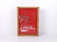 Front view of Coca-Cola wall clock showing red face and paint loss