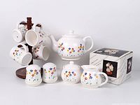 Full set displayed: teapot, sugar, creamer, shakers, four mugs on wooden stand, box