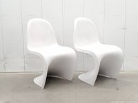 Front three-quarter view of both white fiberglass Panton-style chairs