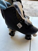 Side view of both Chicago quad roller skates showing leather uppers, wheels, attached tag