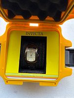 Watch in foam insert inside yellow Invicta case