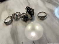 Five sterling rings laid out on marble surface