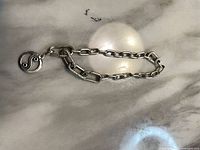 Full view of chain link bracelet laid flat showing charm and links
