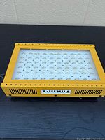 Front of yellow TMLAPY LED grow light showing LED array under lens