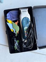 Open case displaying Wahl clipper, color guards and cord