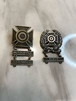 Front view of both sterling U.S. Army marksmanship badges and attached weapon qualification bars
