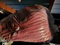 Red textured bean bag chair inside clear plastic bag