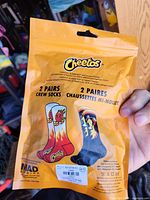 Front of sealed retail package showing Cheetos branding and two illustrated sock designs