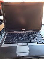 Front view of Dell Latitude D620 laptop open, showing screen, keyboard, trackpad and palm rest