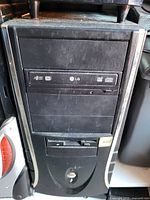 Front view of black/silver desktop tower showing LG optical drive and floppy drive