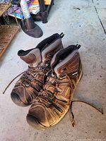 Overall view of both KEEN boots showing color, style, wear, and frayed laces