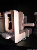 White plastic manual spiralizer showing hand crank, frame, and suction base