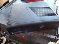 Top and front view of black Xbox 360 S console showing overall cosmetic condition