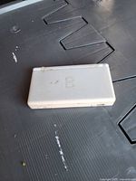 Closed Nintendo DS Lite showing exterior wear and yellowing