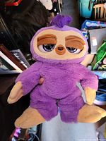 Front view of purple sloth plush stuffed animal showing overall design, coloration, and condition