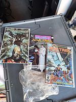 Three Star Trek franchise comic books laid out on plastic tote