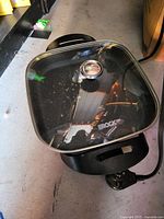 Top view of square Starfrit The Rock electric skillet with glass lid, attached temperature-control cord visible