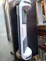 Underside side profile of white hoverboard showing wheels, deck, footpads, and wear