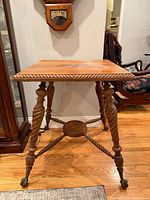 Full view of oak parlor table showing square top, barley twist legs, claw feet