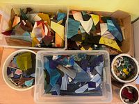 Top view of tubs and containers filled with assorted stained glass pieces