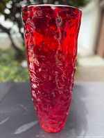 Full view of tall red textured glass vase