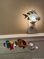 overall view showing night-light plugged in and two wood fish figures on shelf