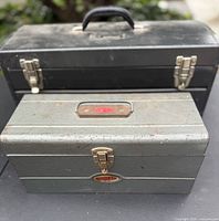 Front view of both metal toolboxes showing size difference, latches, handles and wear