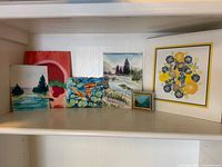 All seven artworks displayed on shelf