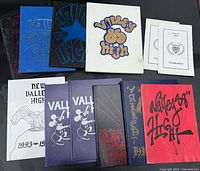 All yearbooks and programs laid out, showing cover designs and count