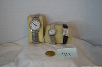 All three wristwatches side by side with scale coin