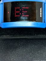 Close-up of watch face showing red LED dots and Diesel logo