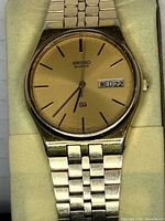 Dial and bracelet close-up showing day-date and gold tone