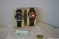 Front view of both watches on stands