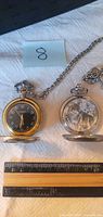 Both pocket watches open beside ruler showing 45 mm case size