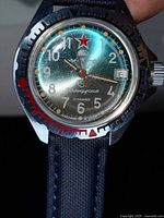 Close-up of watch face showing dial, bezel, crown, strap