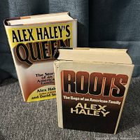 Front view of both hardcover books Roots and Queen showing dust jackets