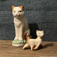 Front view of both cat figurines side by side