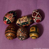 Group shot of all six decorated eggs on purple background