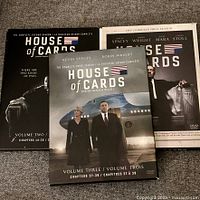 Three House of Cards DVD season box sets laid out: Seasons 1-3