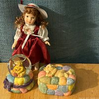 Group shot showing porcelain doll, snow globe and trinket box