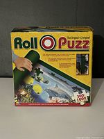 Front of retail box for Roll-O-Puzz puzzle mat system