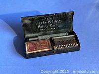 Razor parts in open tin case with blade pack