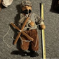 Full view of marionette with crossbar and tape measure for scale