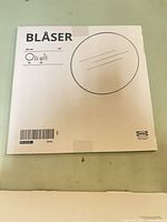 Front of packaged mirror showing IKEA Blåser label