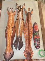 All four wooden masks laid out showing size and paint patterns