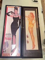 Both framed posters side by side showing subjects, frames, and overall condition