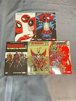 Front view of all five Deadpool trade paperbacks